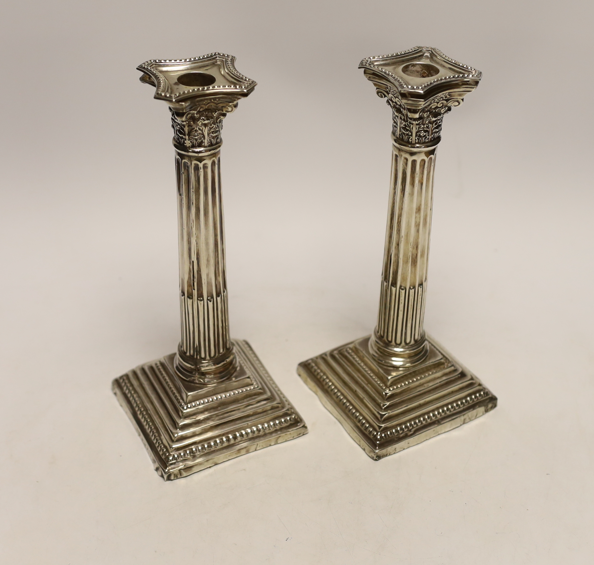 A pair of Edwardian silver Corinthian column candlesticks, by Jones & Crompton, Birmingham, 1903, height 24cm, weighted, (a.f.).